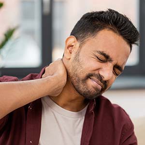 A man holding his neck in pain from a car accident injury.